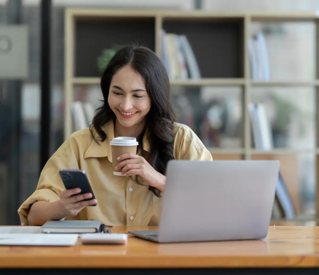 Businesswoman smiling and looking at phone